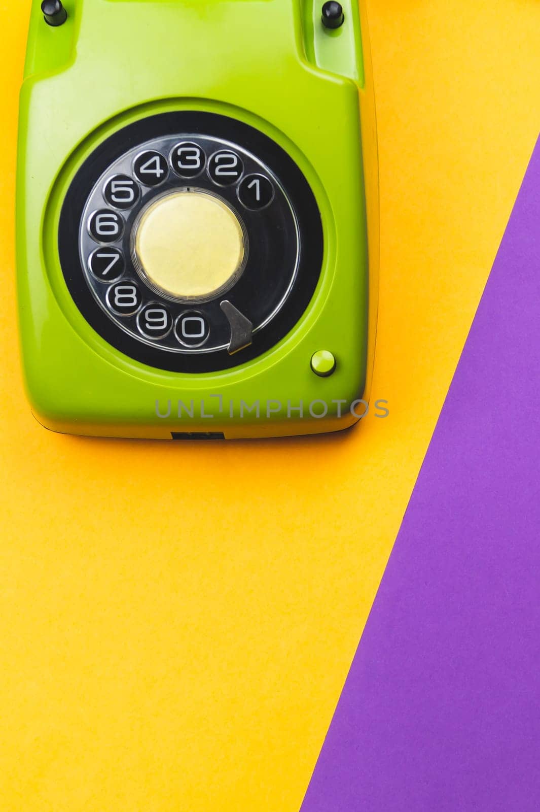 Vintage rotary phone. classic green telephone with round dial on color background. old communication technology. copy space