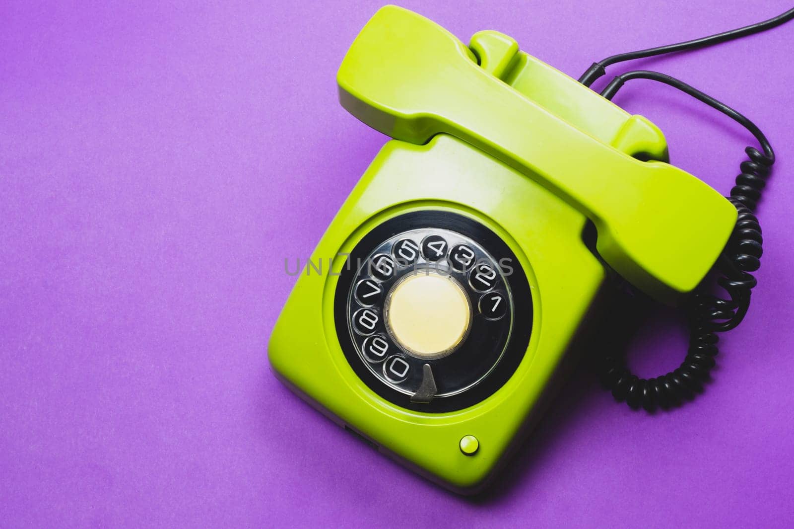 Classic phone with handset. vintage green telephone with phone receiver isolated on purple background. old communication technology. copy space