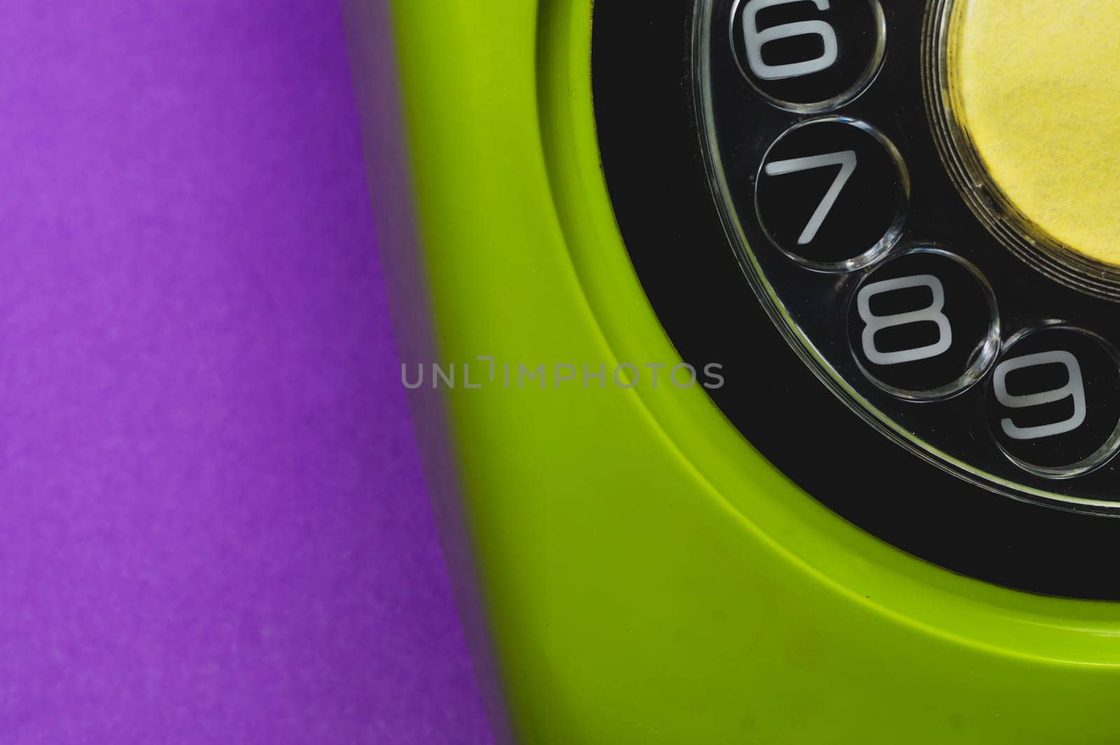 Vintage rotary phone. classic green telephone with round dial isolated on purple background. old communication technology. copy space