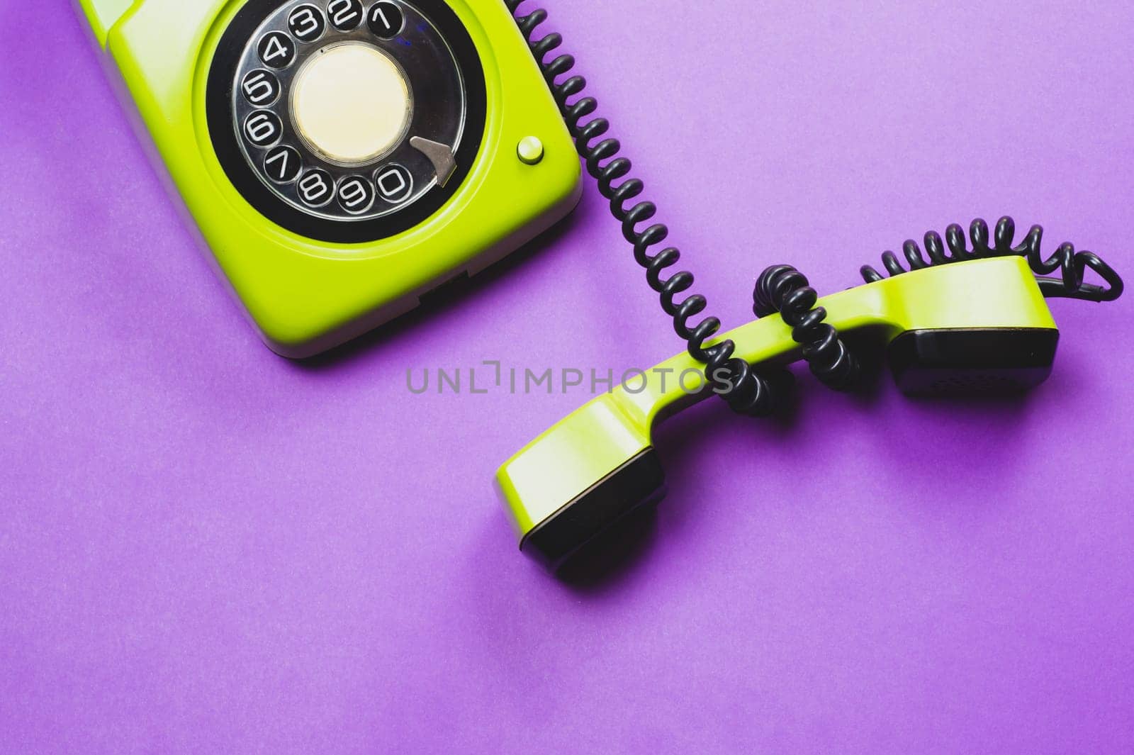 Classic phone with handset. vintage green telephone with phone receiver isolated on purple background. old communication technology. copy space