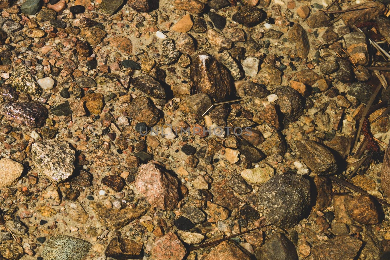 Shiny transparent water. clear water with pebbles and stone on the bottom. shining reflections of sun rays and ripples on the water surface