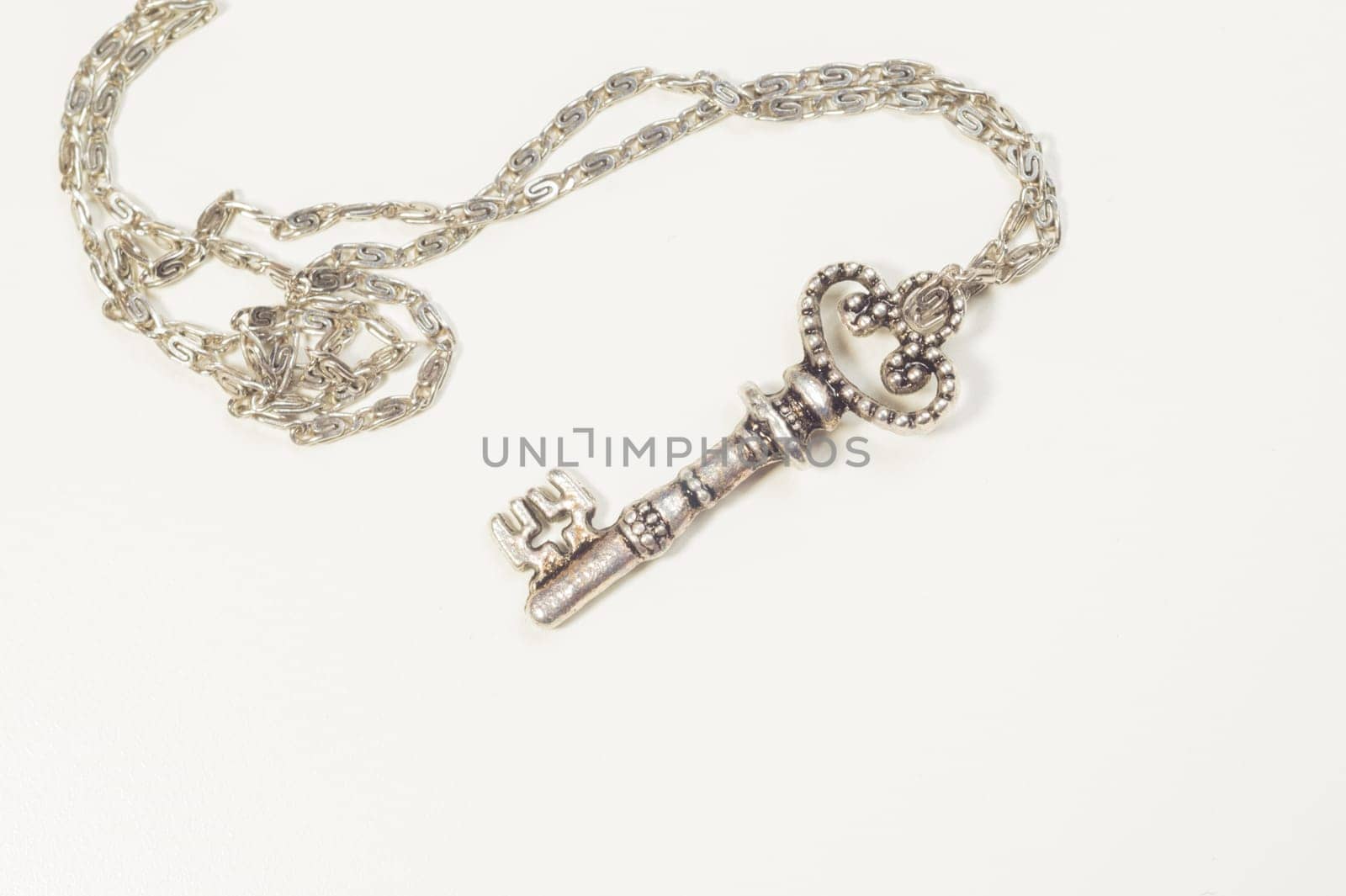 Vintage key with the chain isolated on white background. safety and security concept