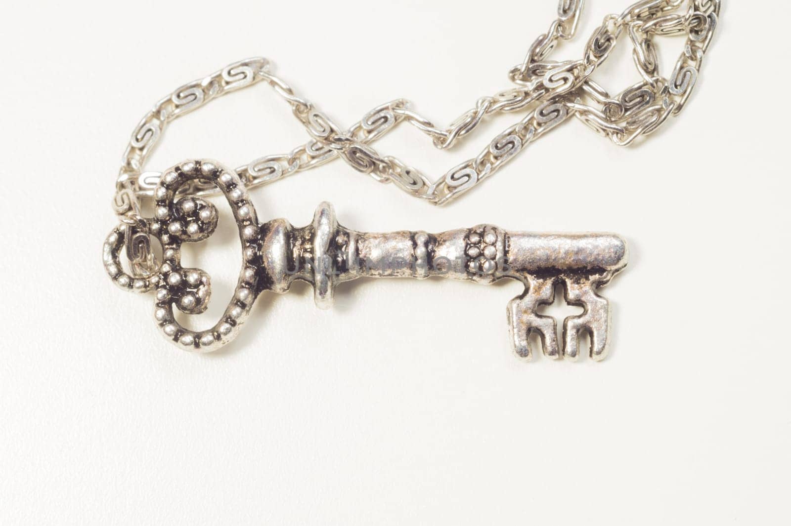 Vintage key with the chain isolated on white background. safety and security concept