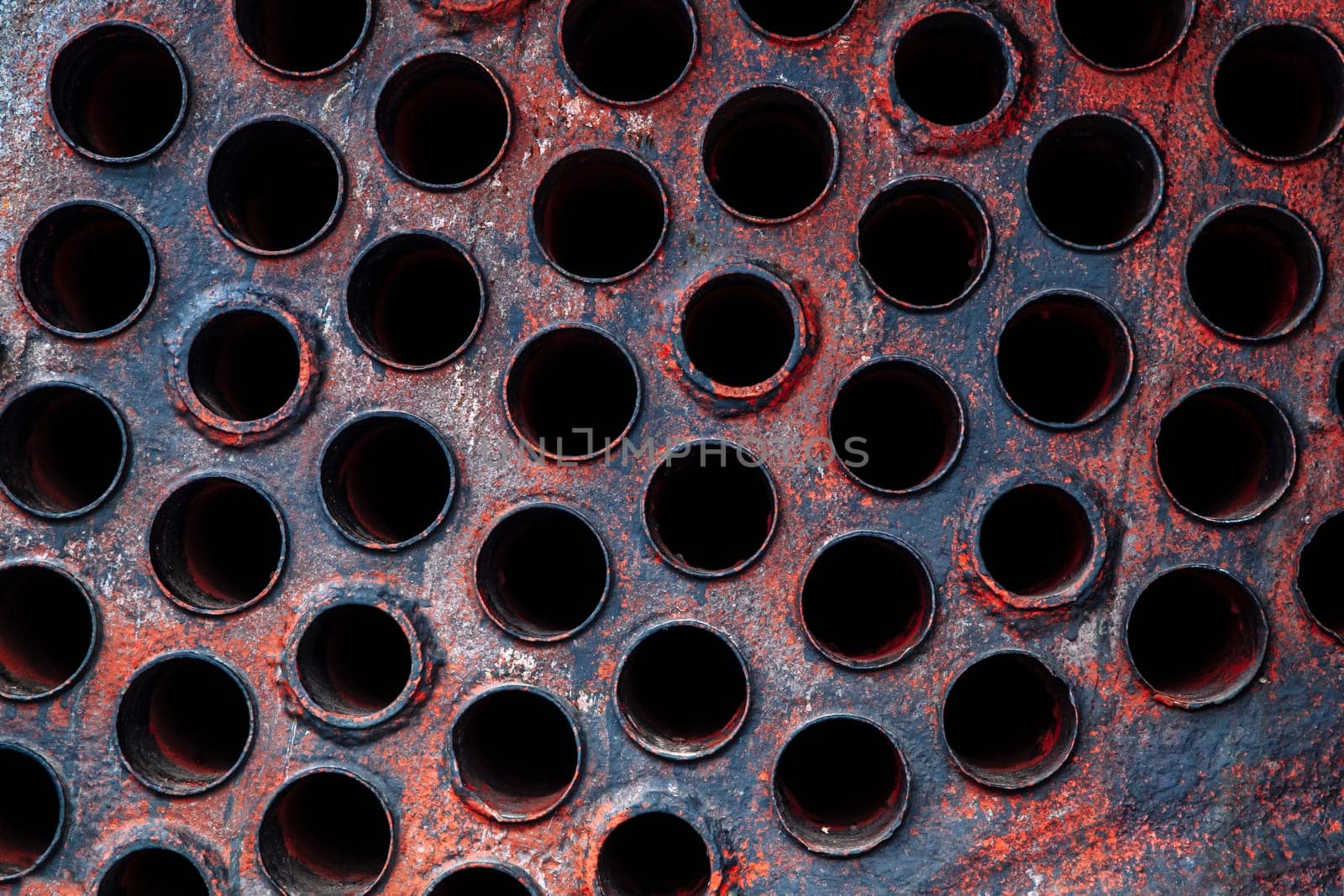 Old and worn industrial metal plate with exhaust ports.