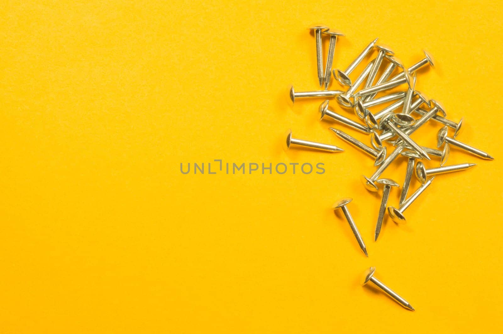 Metal nails isolated on yellow background