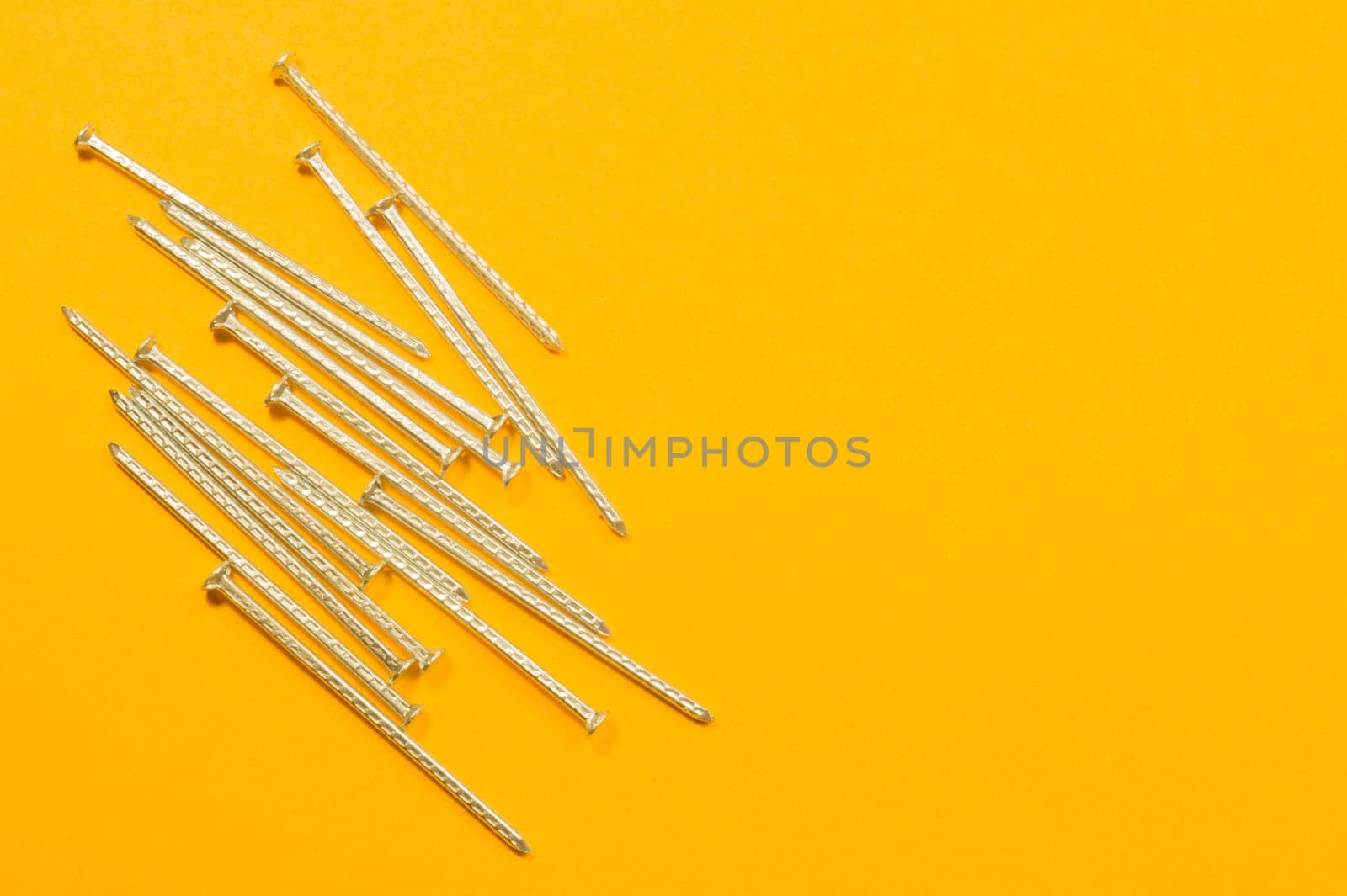 Metal nails isolated on yellow background
