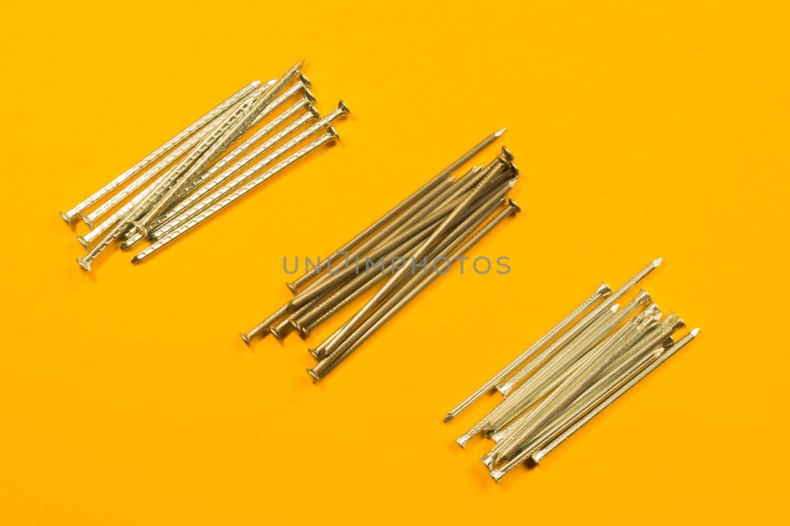 Metal nails isolated on yellow background
