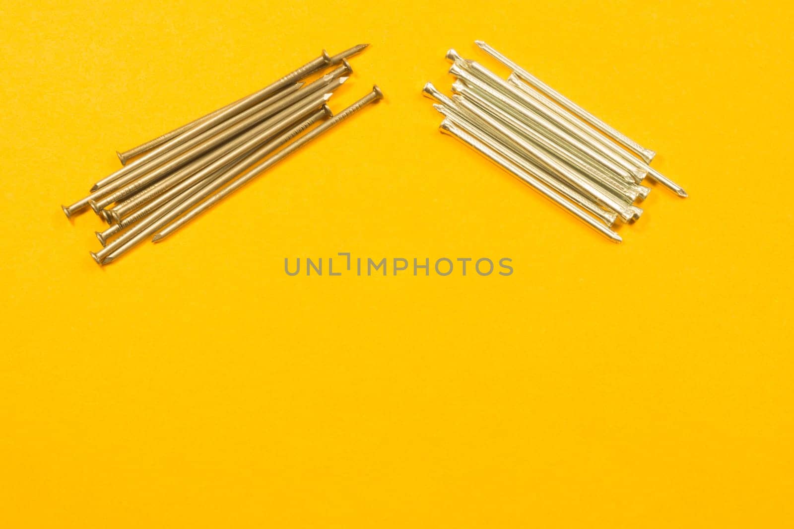 Metal nails isolated on yellow background