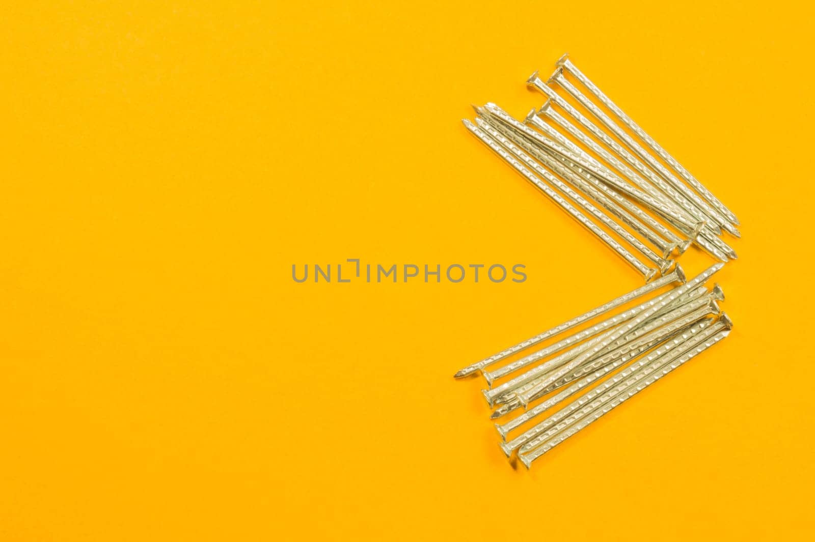 Metal nails isolated on yellow background
