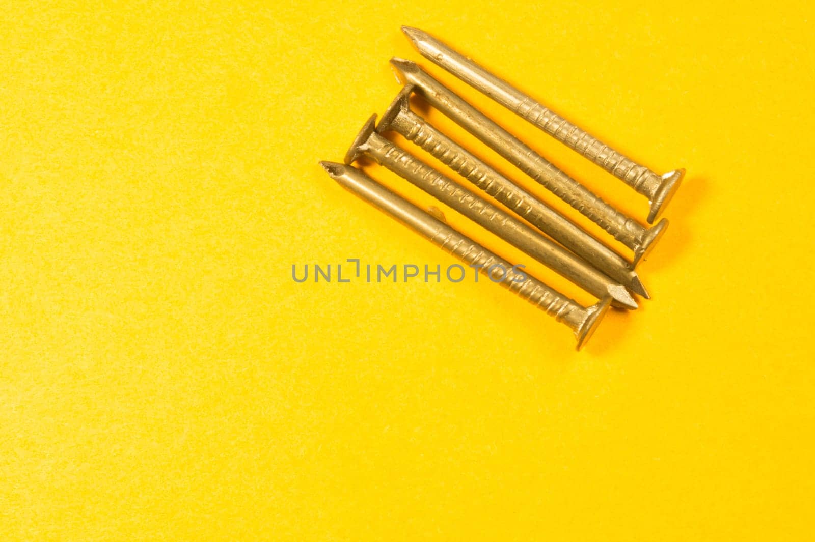 Metal nails isolated on yellow background