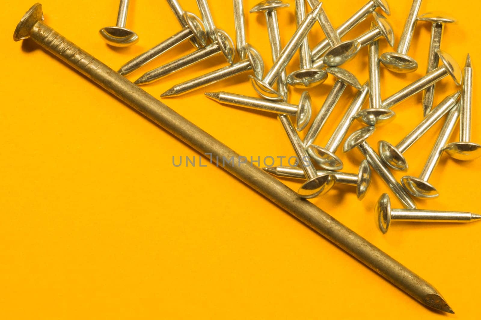 Metal nails isolated on yellow background