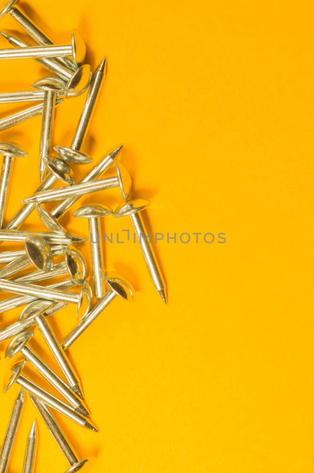 Metal nails isolated on yellow background