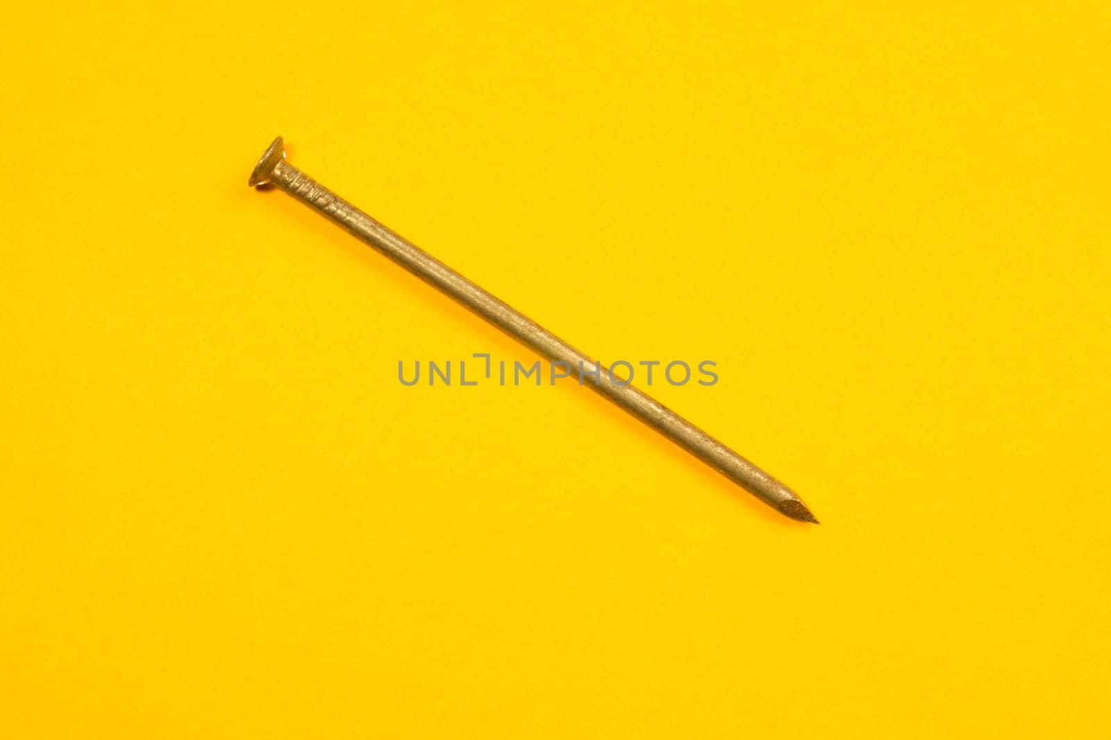 Metal nails isolated on yellow background