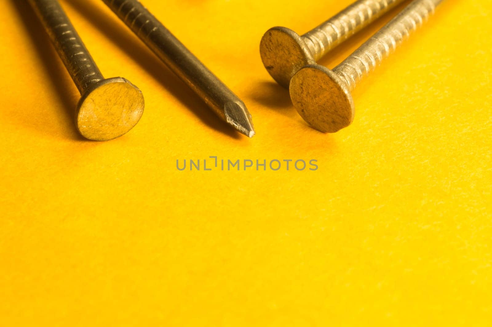 Metal nails isolated on yellow background