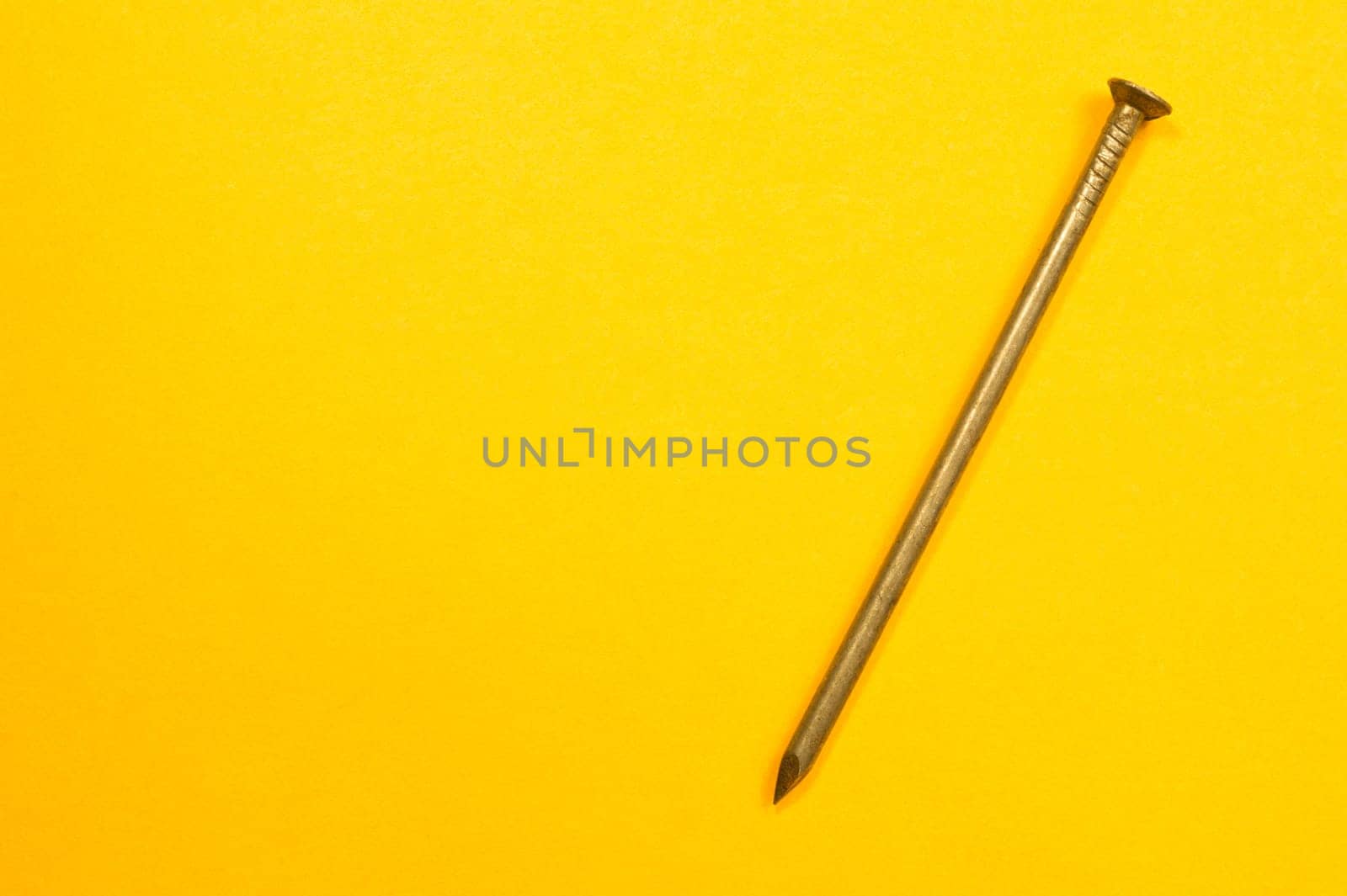 Metal nails isolated on yellow background