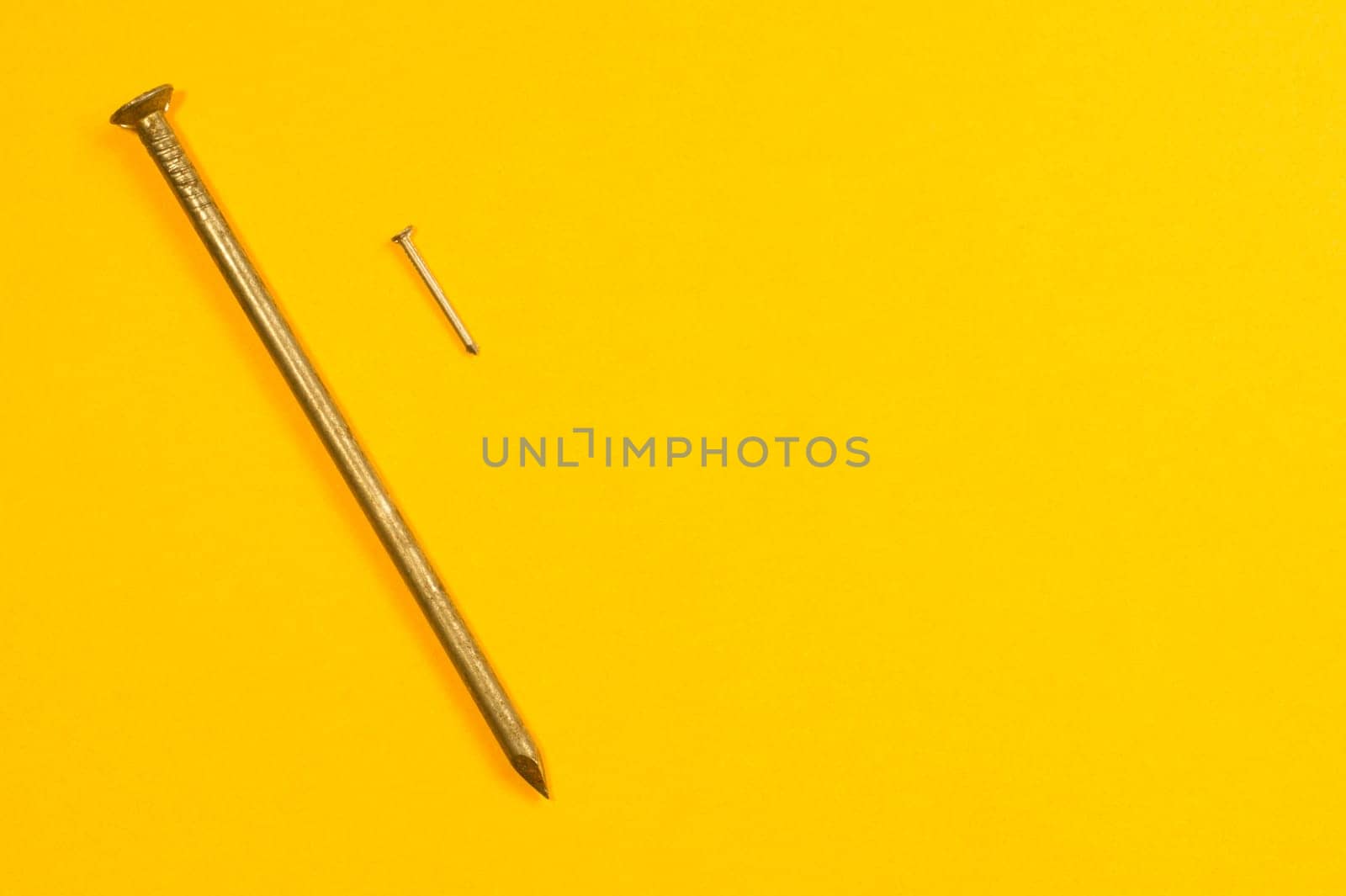Metal nails isolated on yellow background