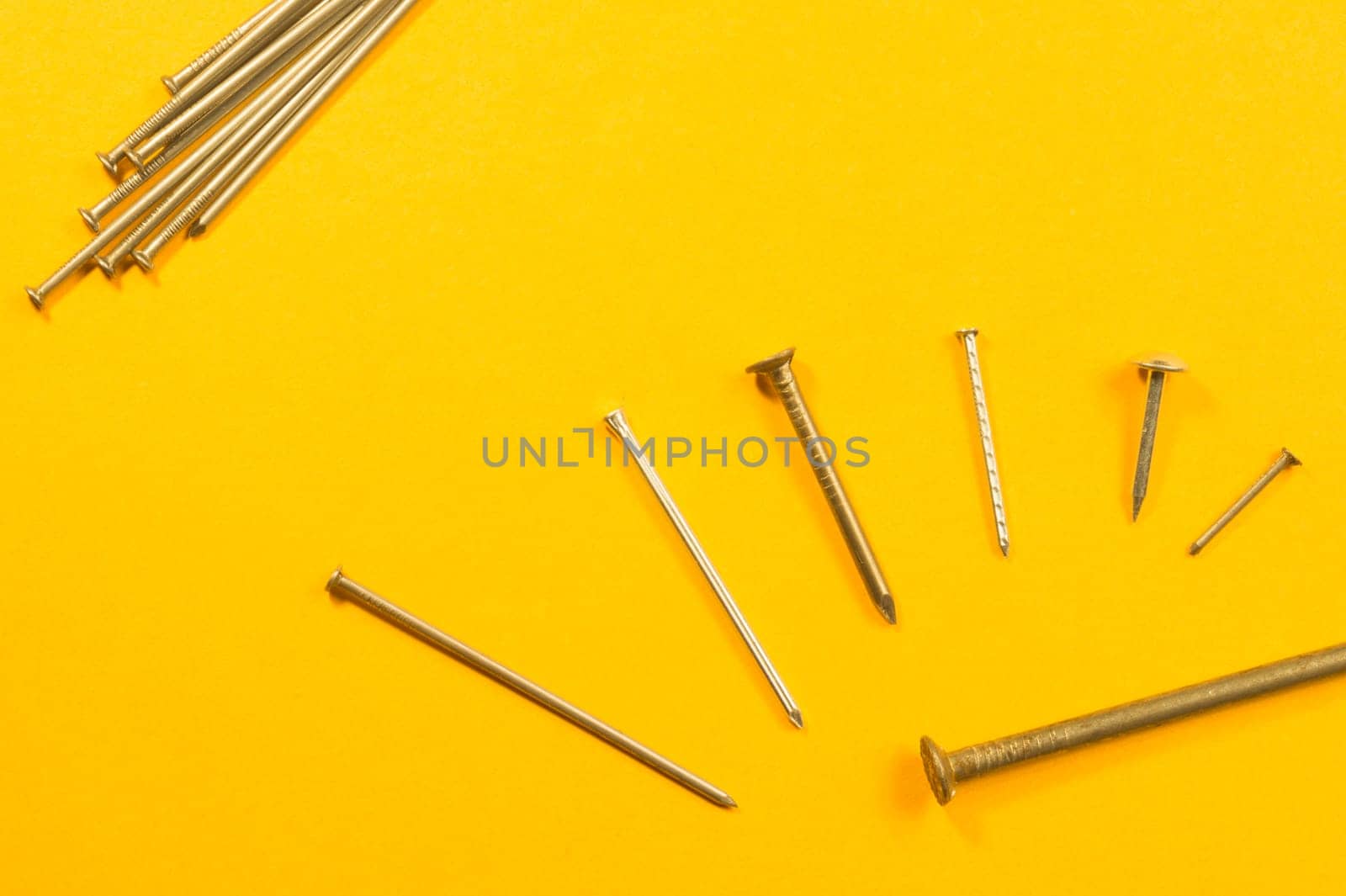 Metal nails isolated on yellow background