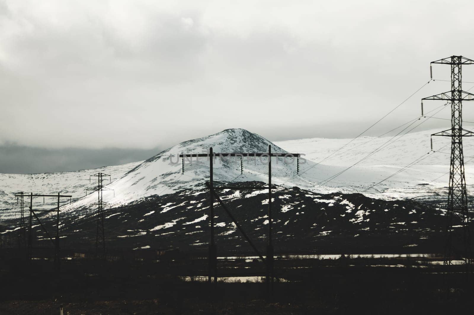 Mountain landscape background. snowy hills and forest. industrial power lines in mountains