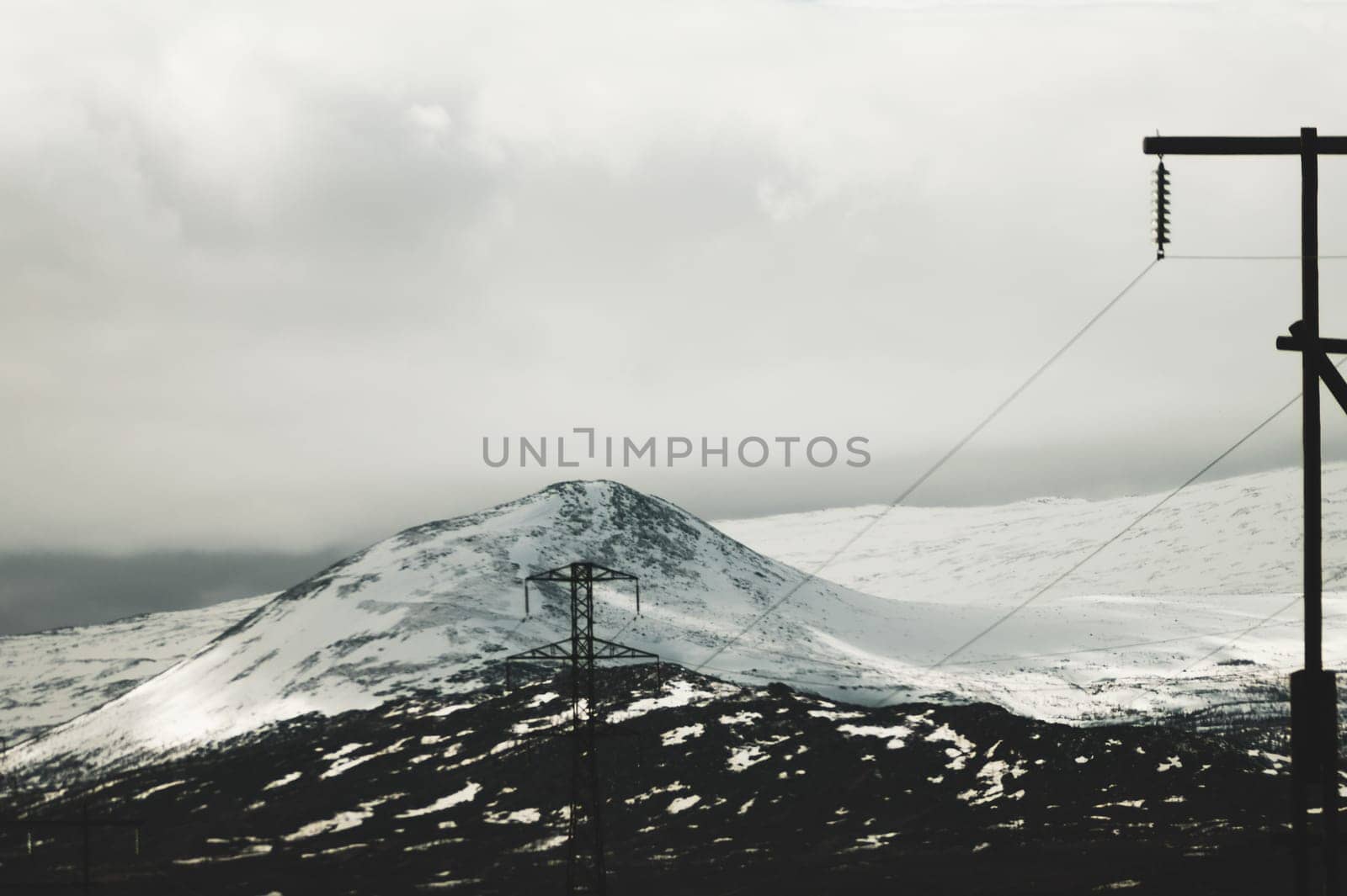 Mountain landscape background. snowy hills and forest. industrial power lines in mountains