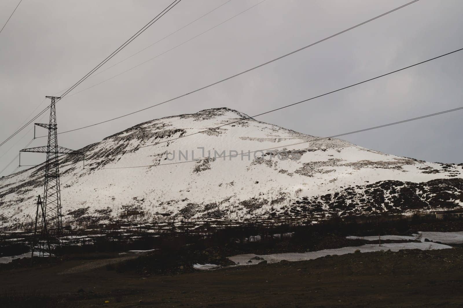 Mountain landscape background. snowy hills and forest. industrial power lines in mountains