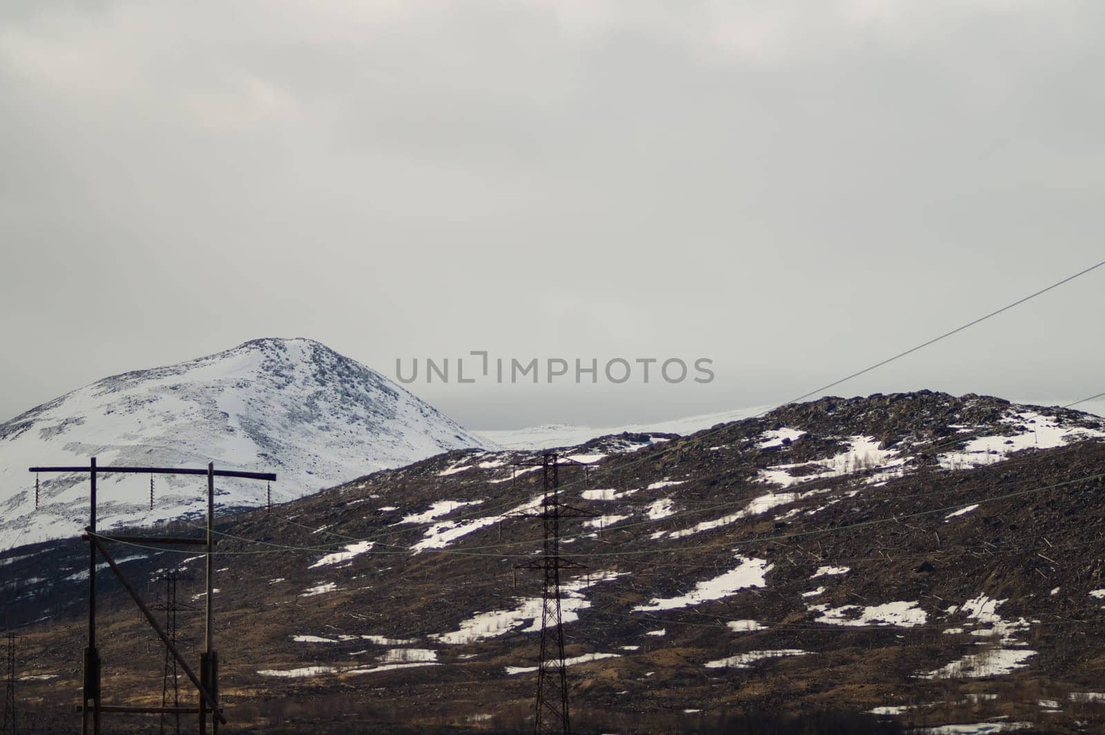Mountain landscape background. snowy hills and forest. industrial power lines in mountains