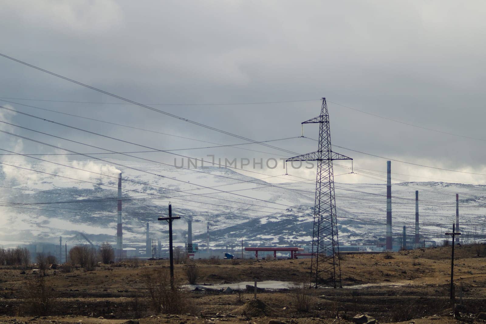 Mountain landscape background. snowy hills and forest. industrial power lines in mountains