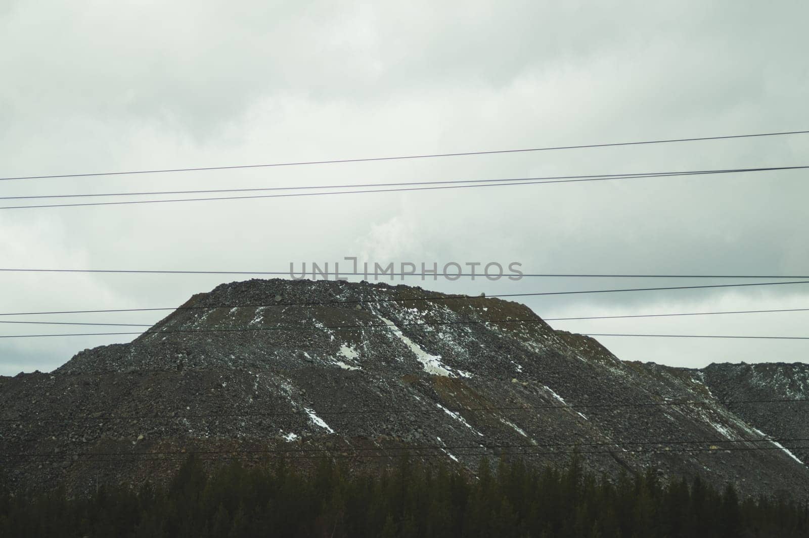 Mountain landscape background. snowy hills and forest. power lines in mountains