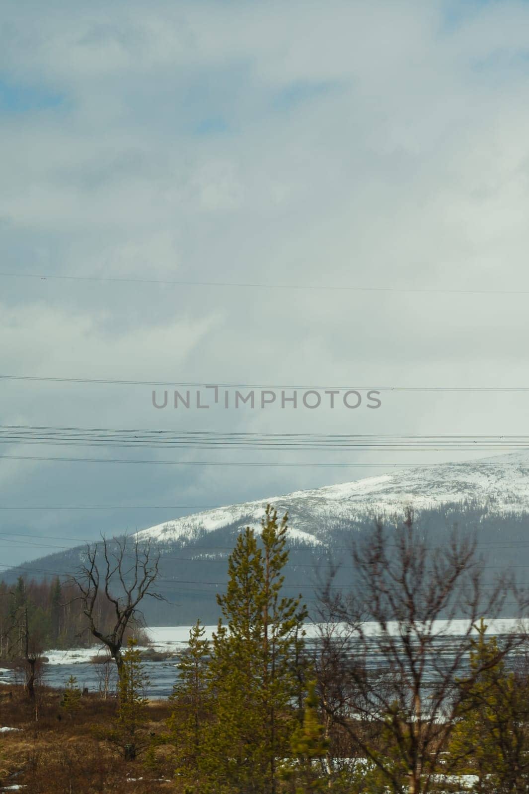 Mountain landscape background. snowy hills and forest. industrial power lines in mountains