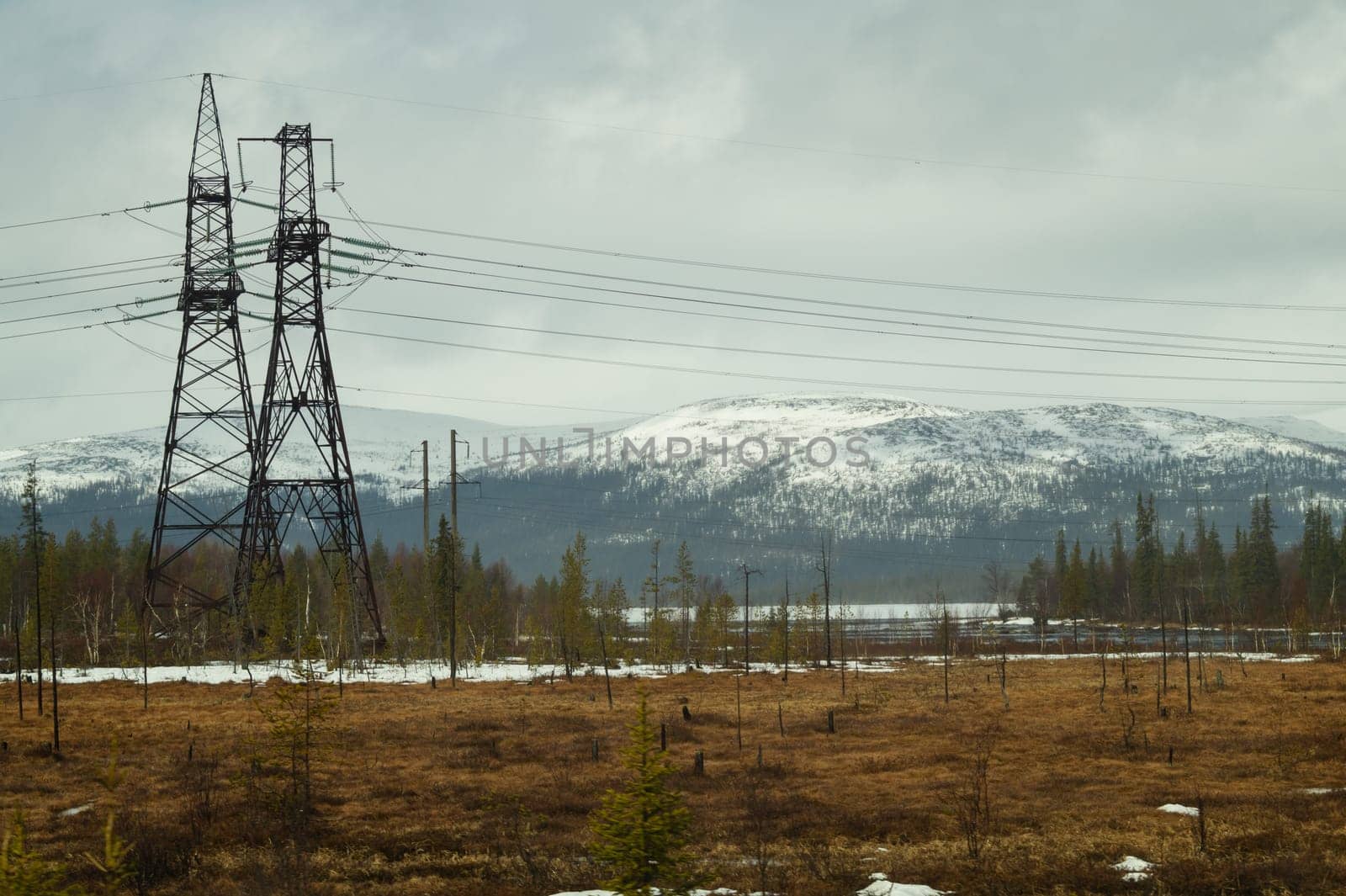 Mountain landscape background. snowy hills and forest. industrial power lines in mountains