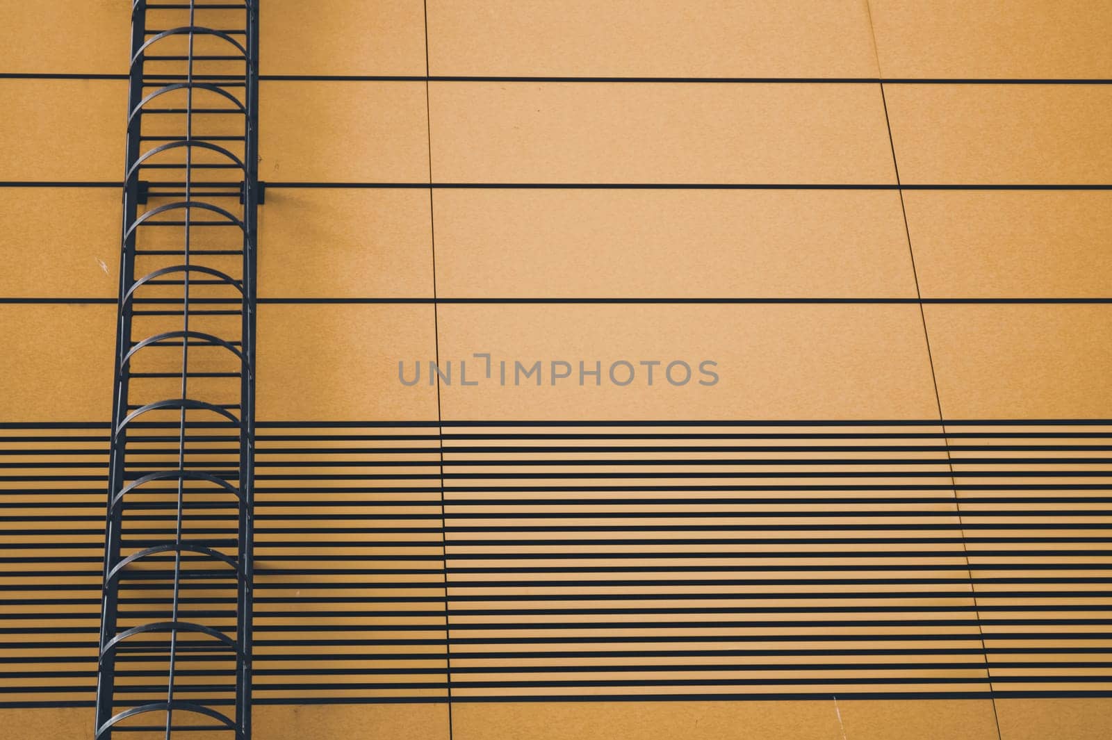 Brown wall of modern building with emergency ladder background
