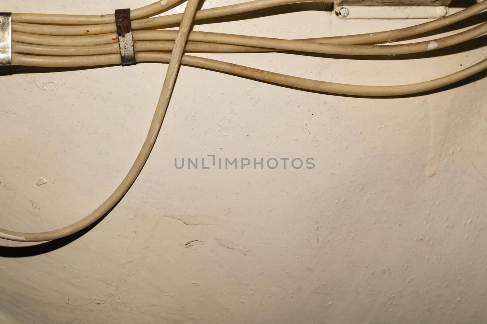 Old electrical wires or cables hanging on the wall. industrial background