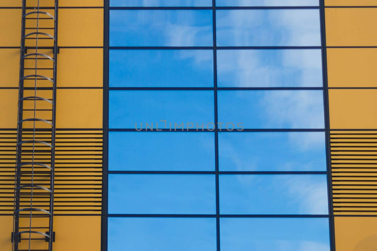 Glass wall of business center with sky reflection. modern building with large mirror window