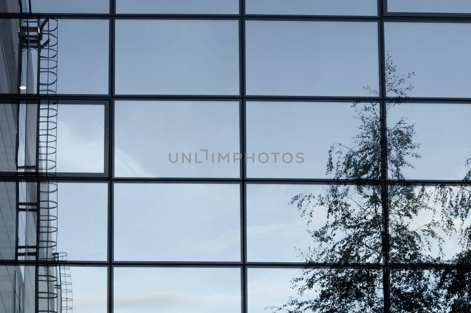 Glass wall of business center with sky reflection. modern building with large mirror window