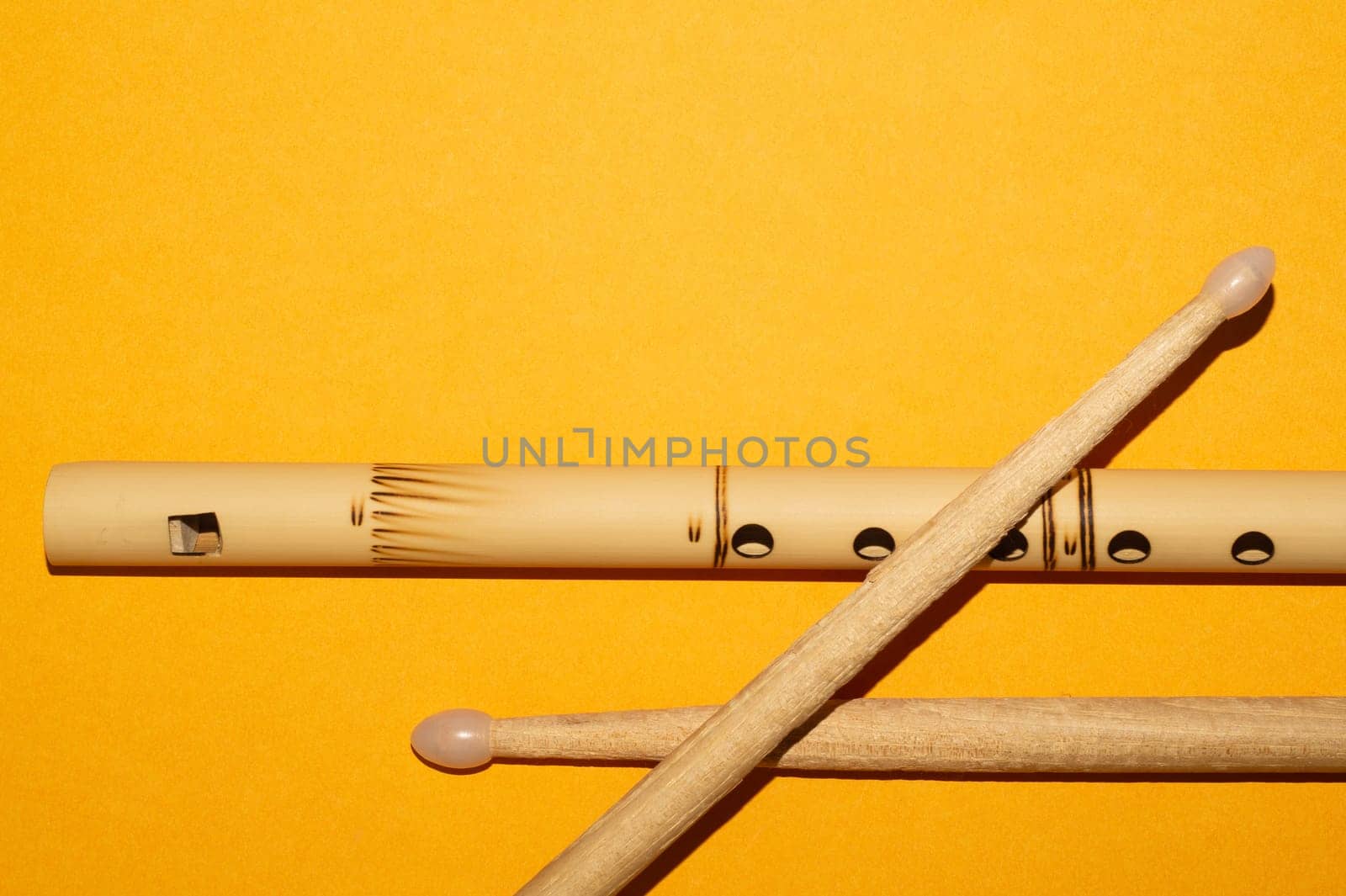 Bamboo bansuri flute and drumsticks. simple music instruments
