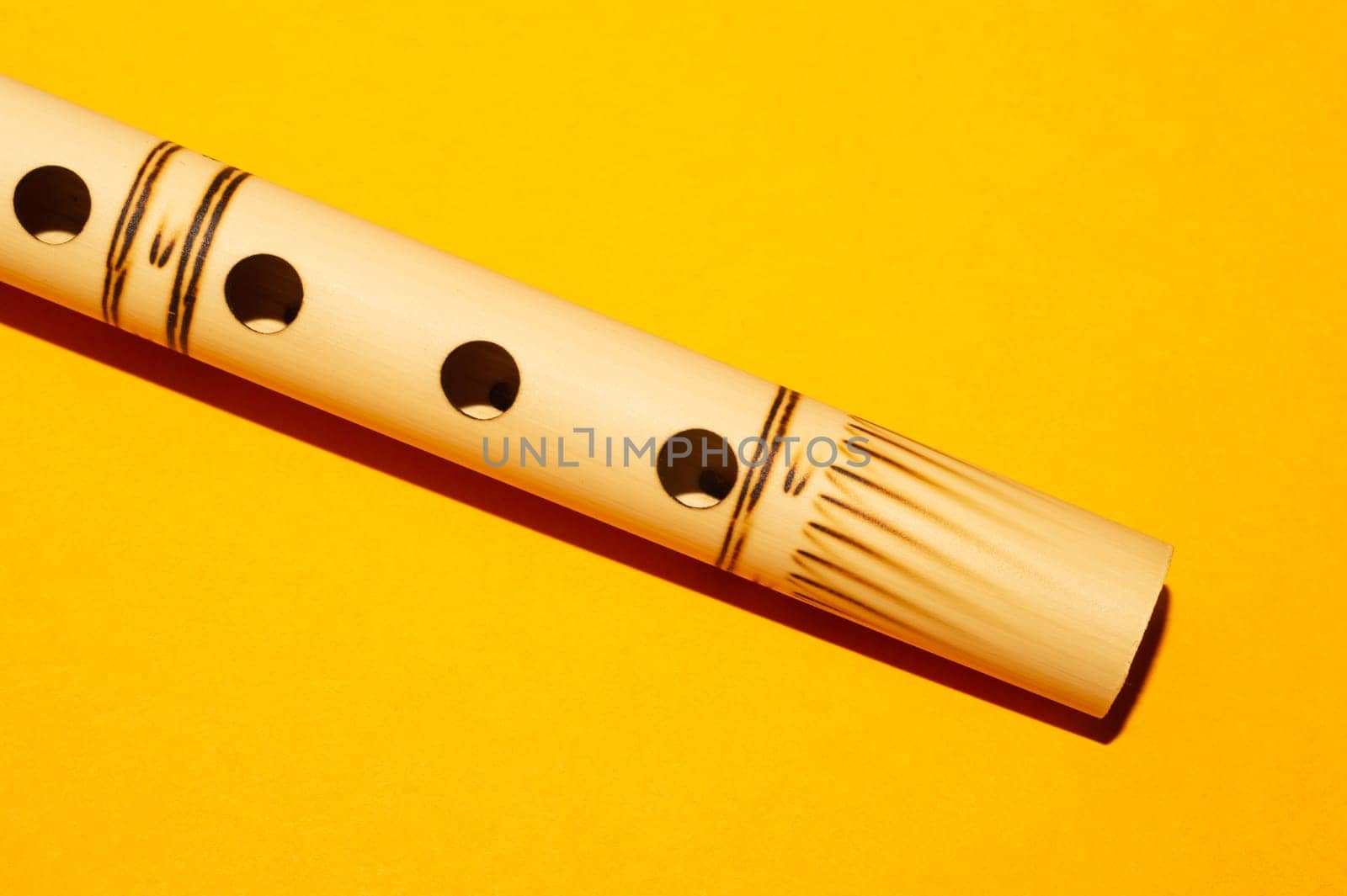 Bamboo flute. simple wind instrument. bansuri flute on yellow background