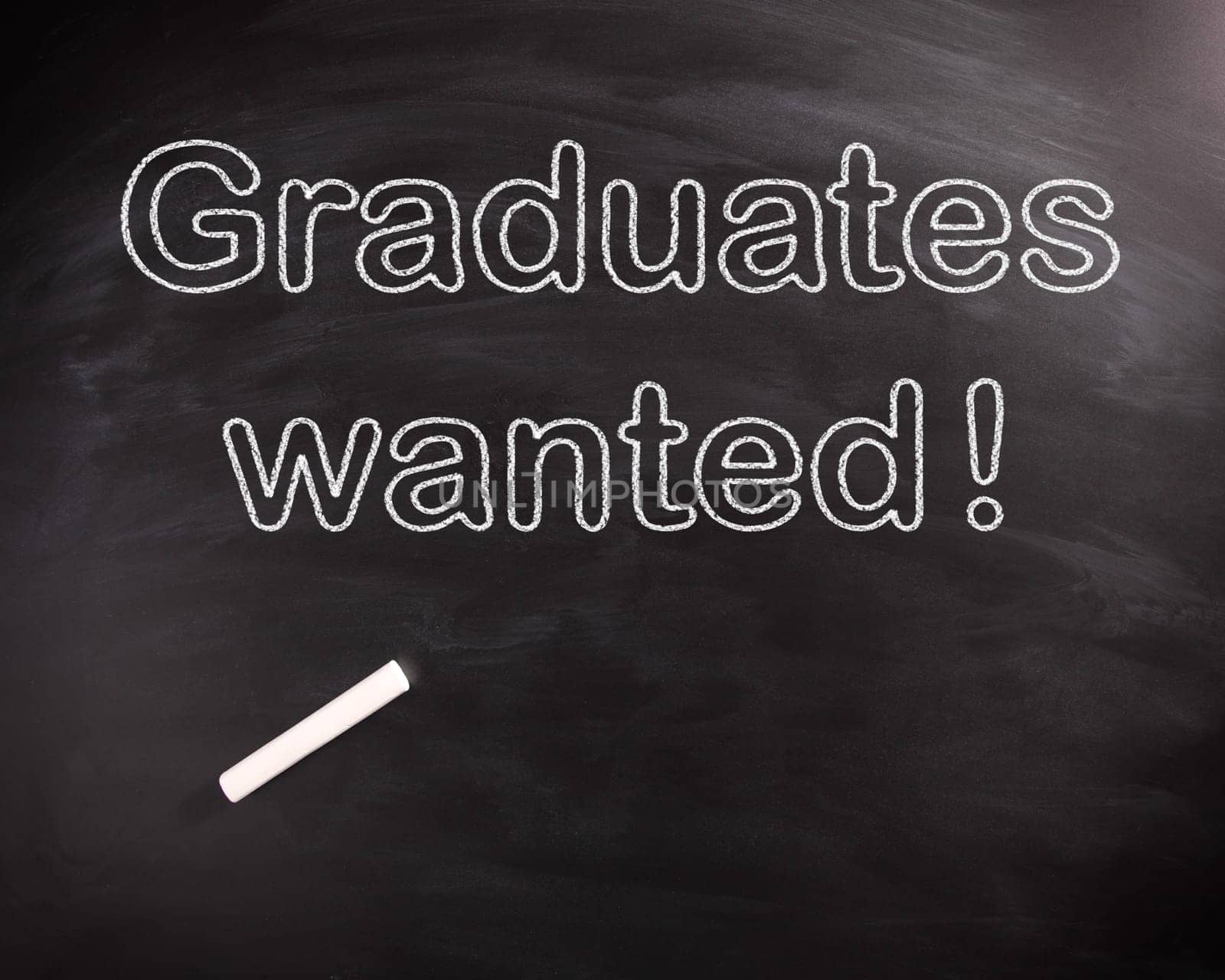 Conceptual Graduates Wanted Phrase on Black Chalkboard, Captured on High Angle View.