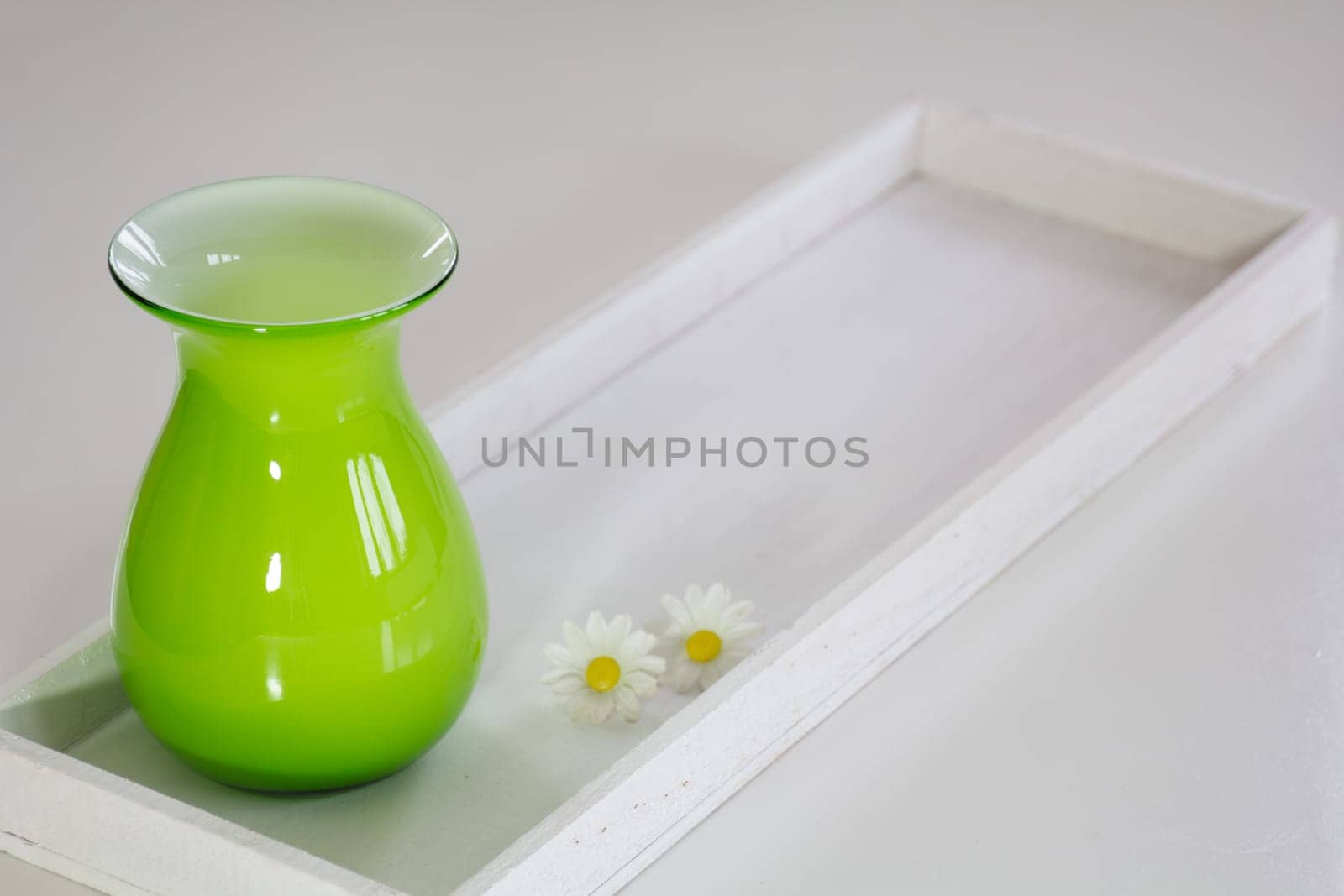 Green vase on a white tray