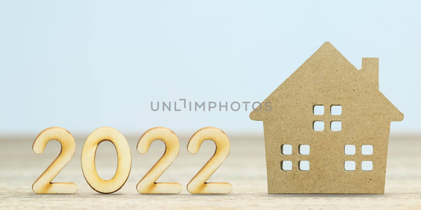 Wooden numeric new year 2022 house model on table with copy space