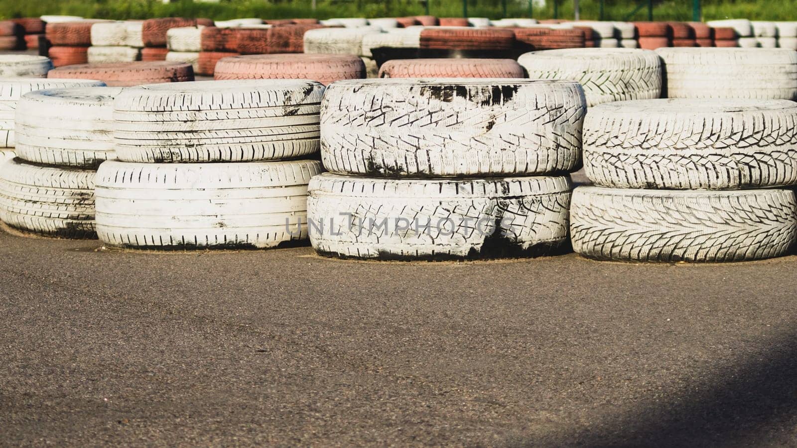 Race track safety barrier. asphalt racing track with red and white tires. colorful tires stack. karting race track