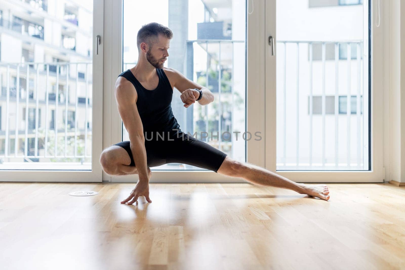 Young handsome man practicing yoga at home