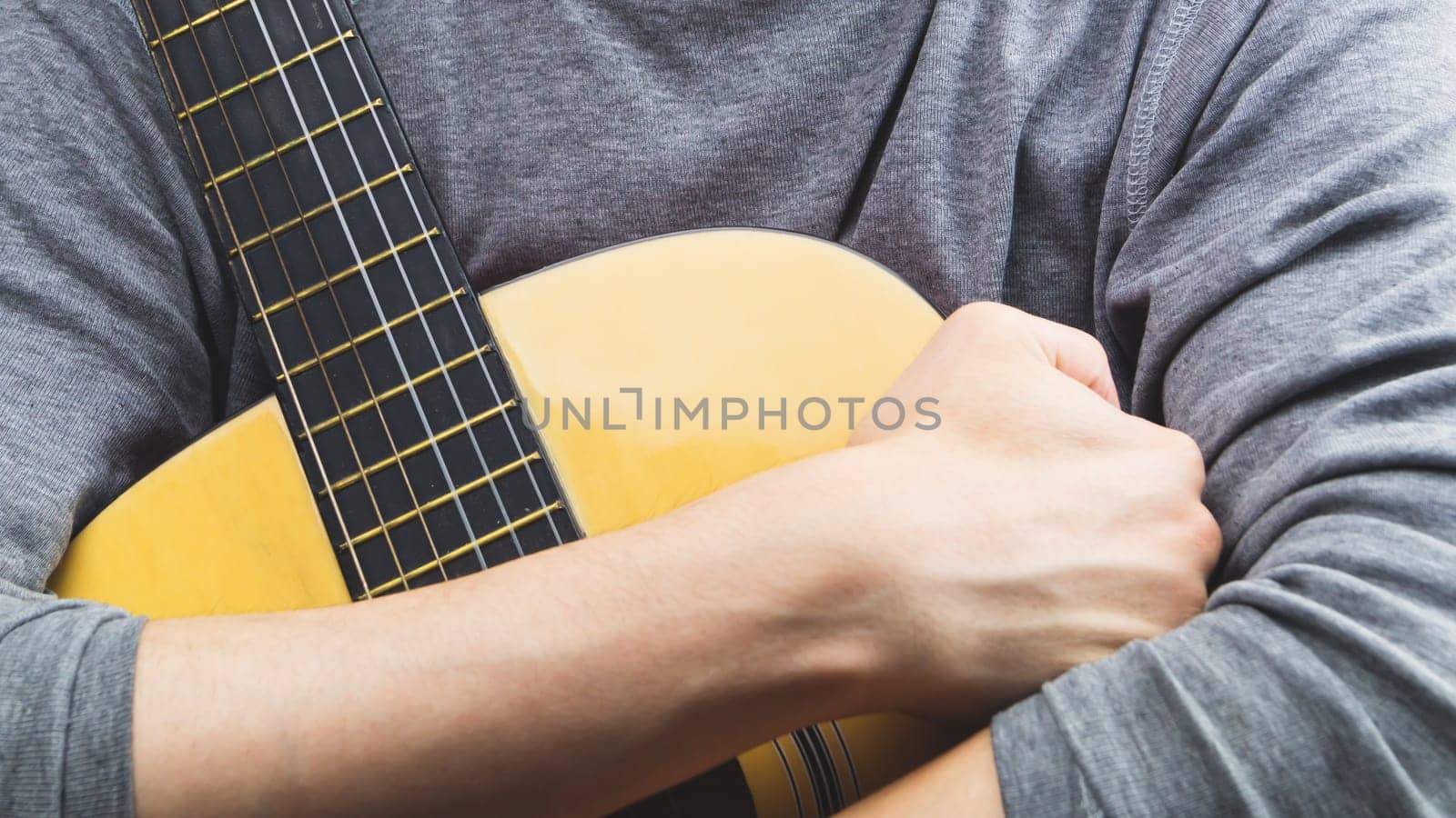 Man holds acoustic guitar. string instrument
