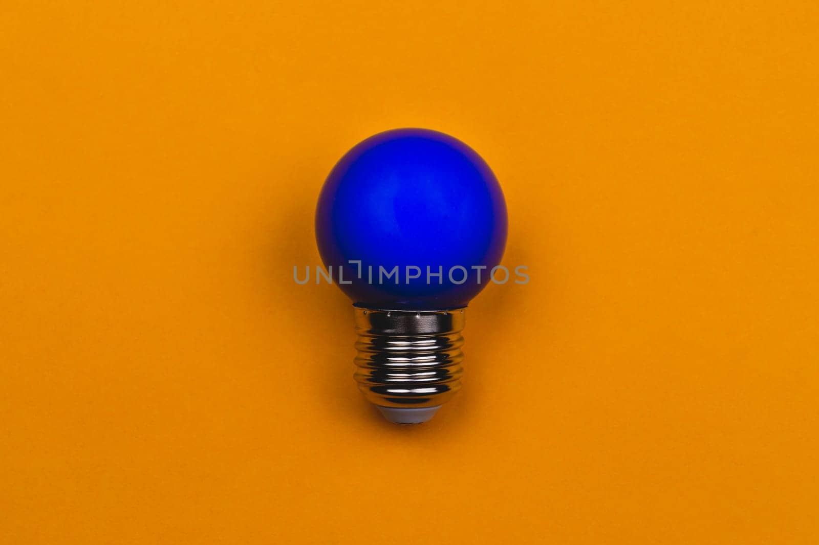 Blue light bulb on a yellow background. single bulb with copy space