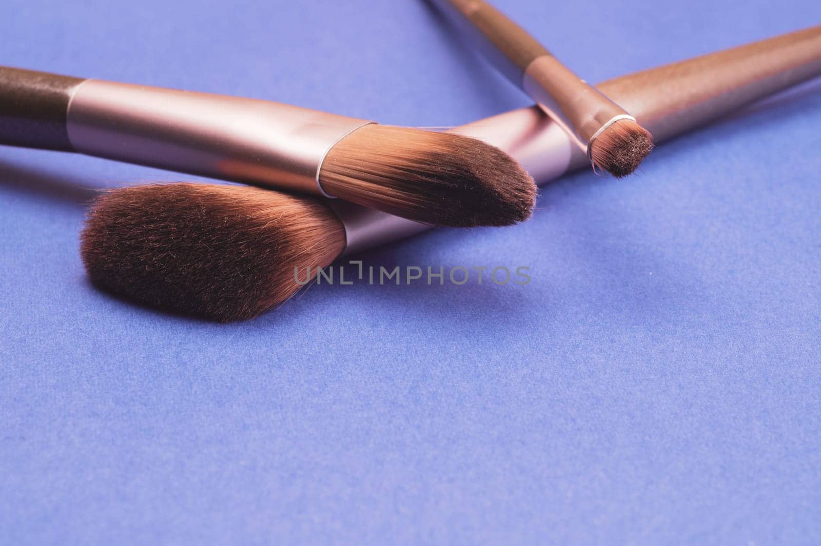 Makeup brushes on blue background. various cosmetic brushes close up. skin care accessories