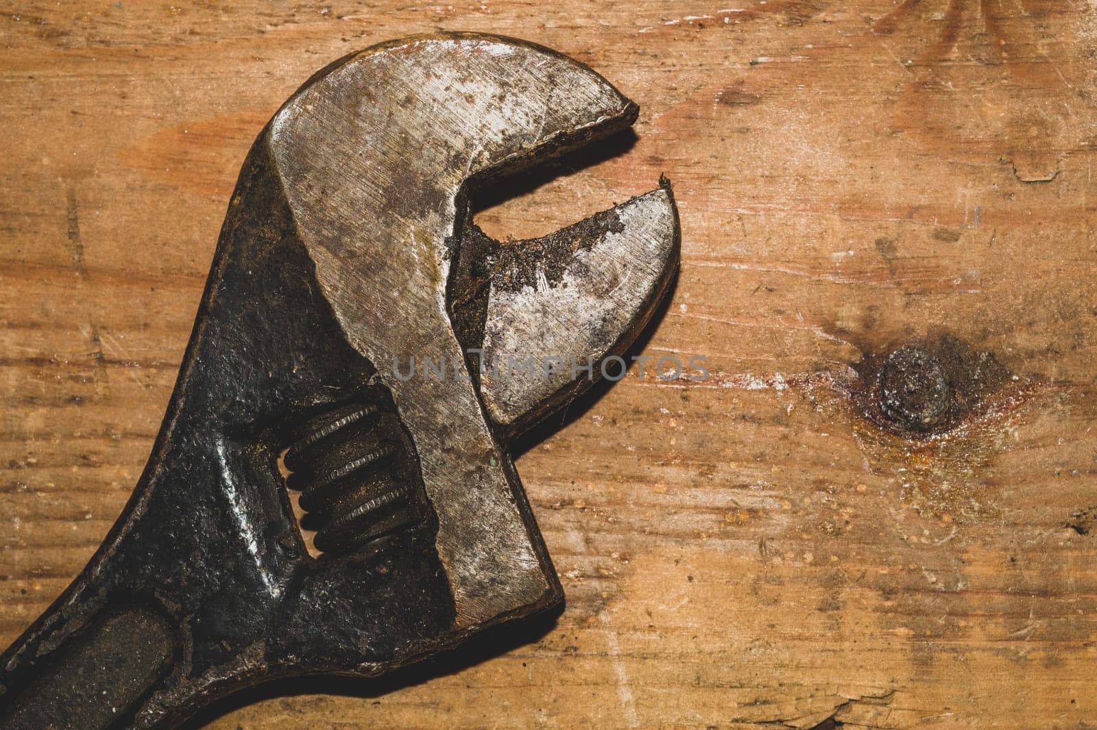 Old adjustable wrench on wood background. working tool. plumbing repairing instrument