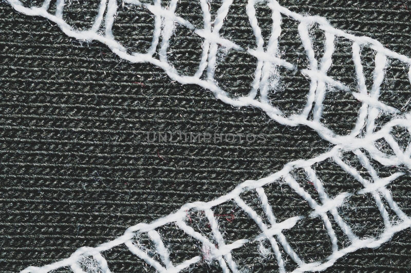 White seams on black fabric. stitches on textile material close up