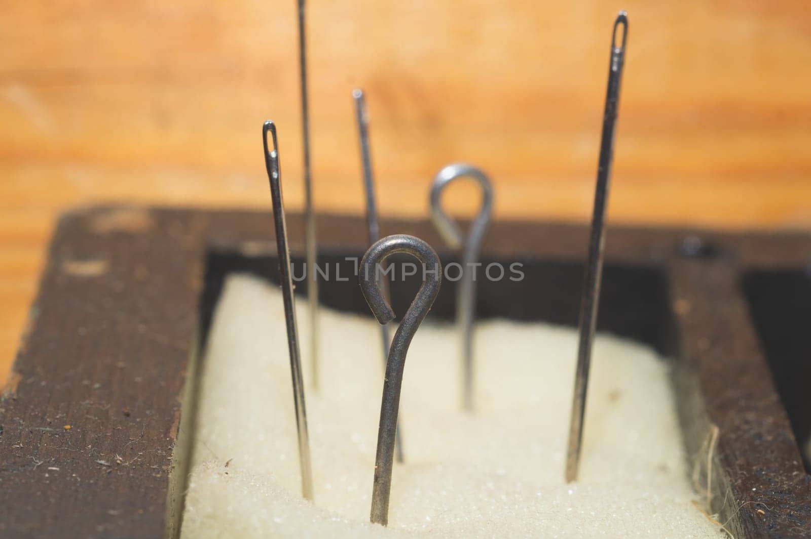 Eyelet of needle close up. sewing needles is inserted into the foam rubber