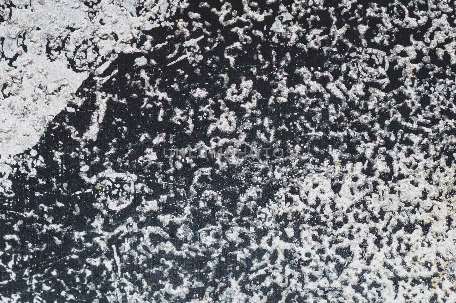 Black steel plate with white paint spots. metal surface with paint splashes. grunge texture. iron background