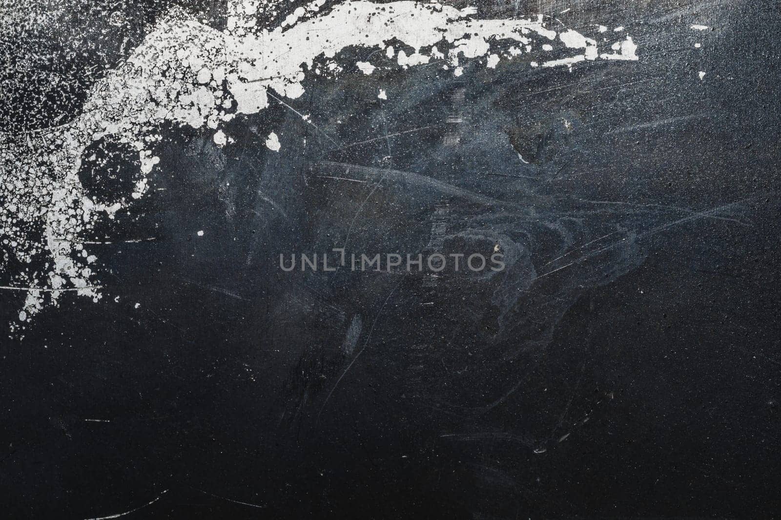 Black steel plate with white paint spots. metal surface with paint splashes. grunge texture. iron background