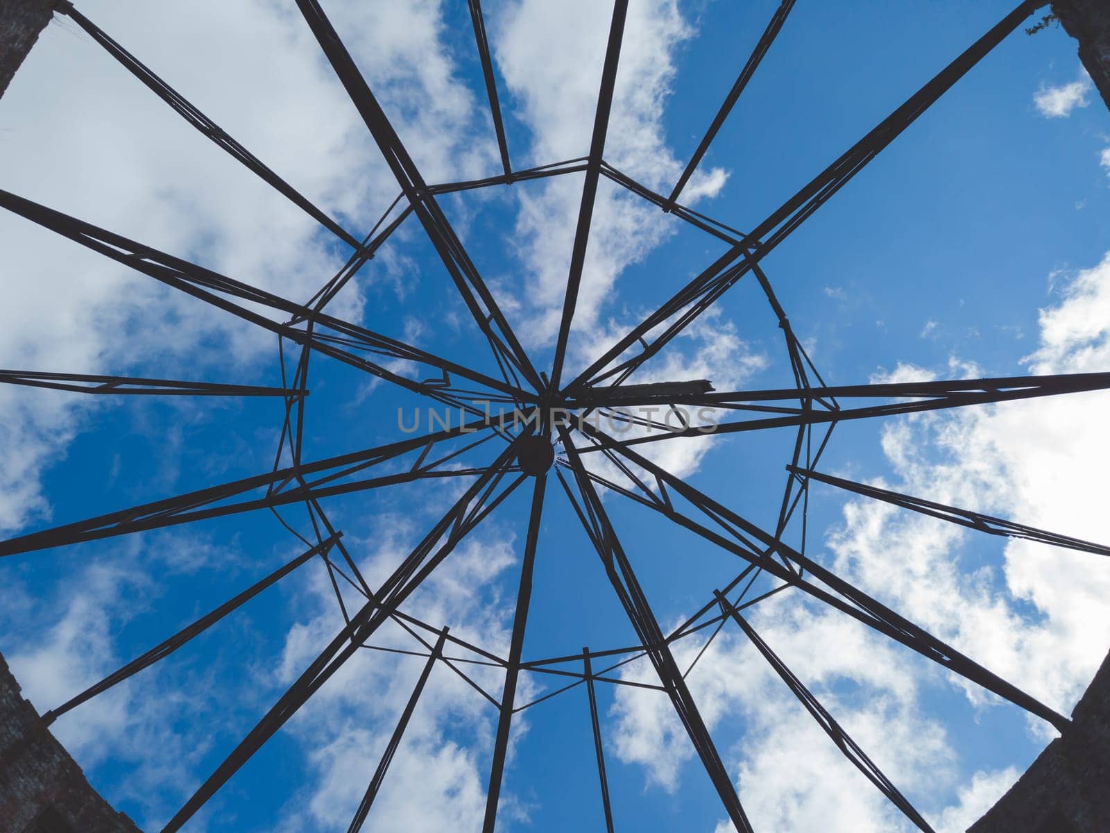 View of the sky through a ruined roof construction. steel carcass for roof mounting