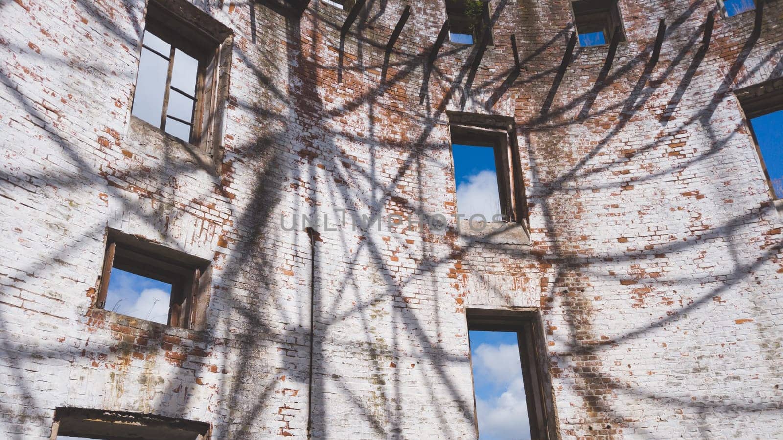 Curved brick wall of ruined building. sky is visible through the windows. part of destroyed house. old architecture